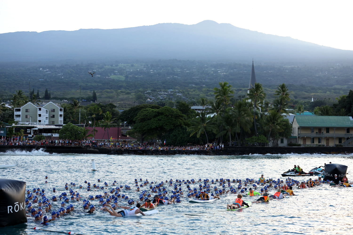 Wasserstart beim Ironman Hawaii. Athleten in blauer Badekappe warten auf den Startschuss
