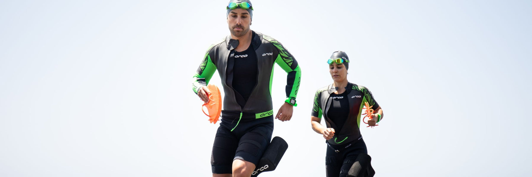 Ein Mann und eine Frau in SwimRun Anzügen kommen aus dem Wasser